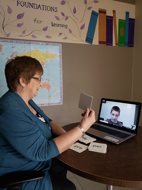 A photo of Sharon Prest, owner of Foundations for Learning, teaching a student through Distance Learning on her laptop.